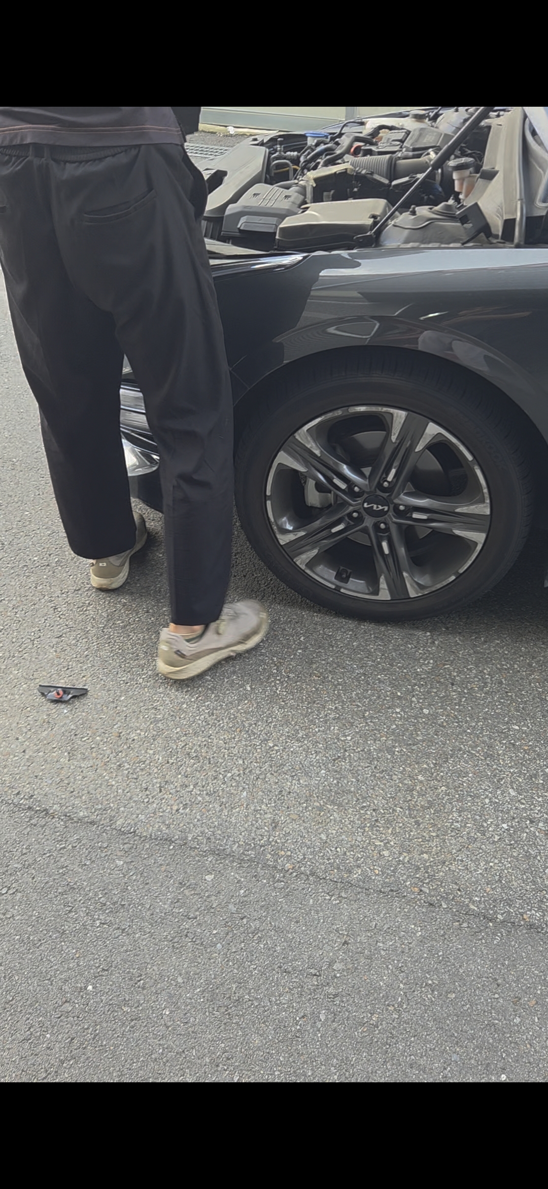 장착점에서 보닛을 열고 자동차 배터리를 교체하는 모습